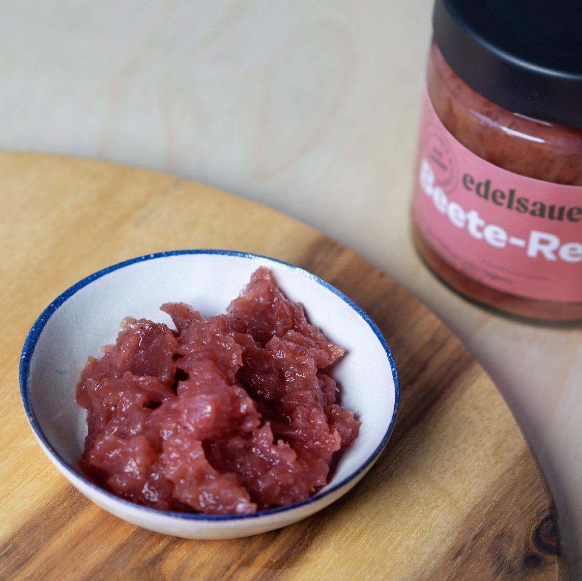 rote bete meerrettich relish in einer weißen schüssel auf einem holz brettchen daneben rote bete meerrettich relish glas von edelsauer