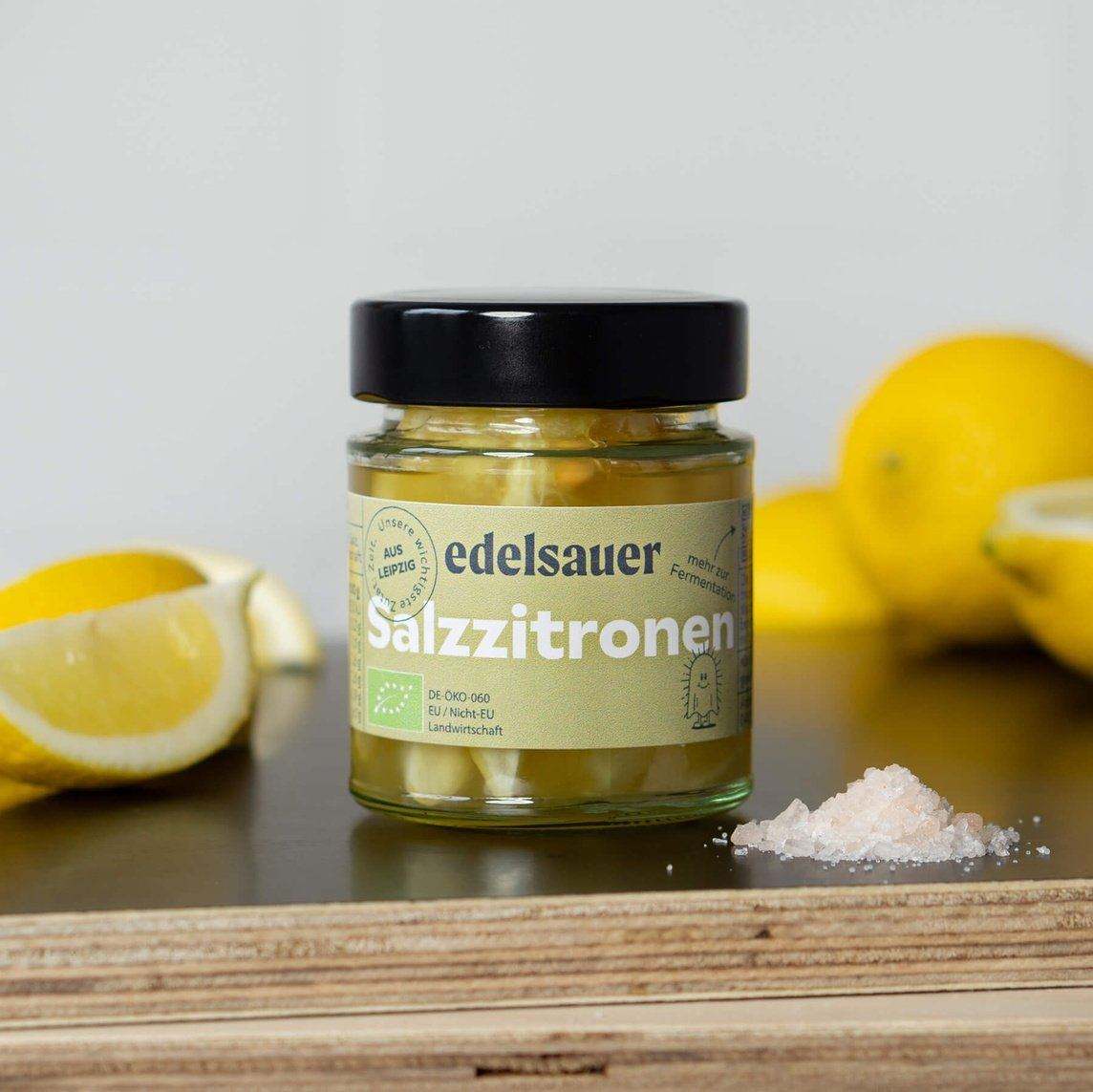 Eingelegte Bio Salzzitronen im Glas auf Holzbrett natürlich fermentierte Zitronen von edelsauer